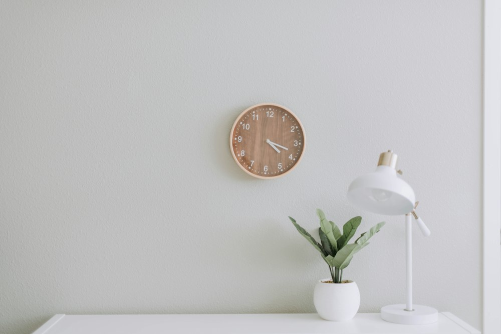 Reloj, lámpara y planta en una consulta